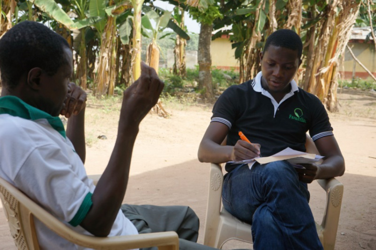 A picture of Patrick Sakyi interacting with one of the farmers he works with